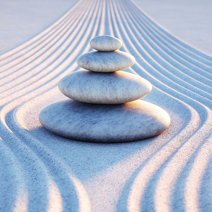 zen garden stacking stones on textured sand