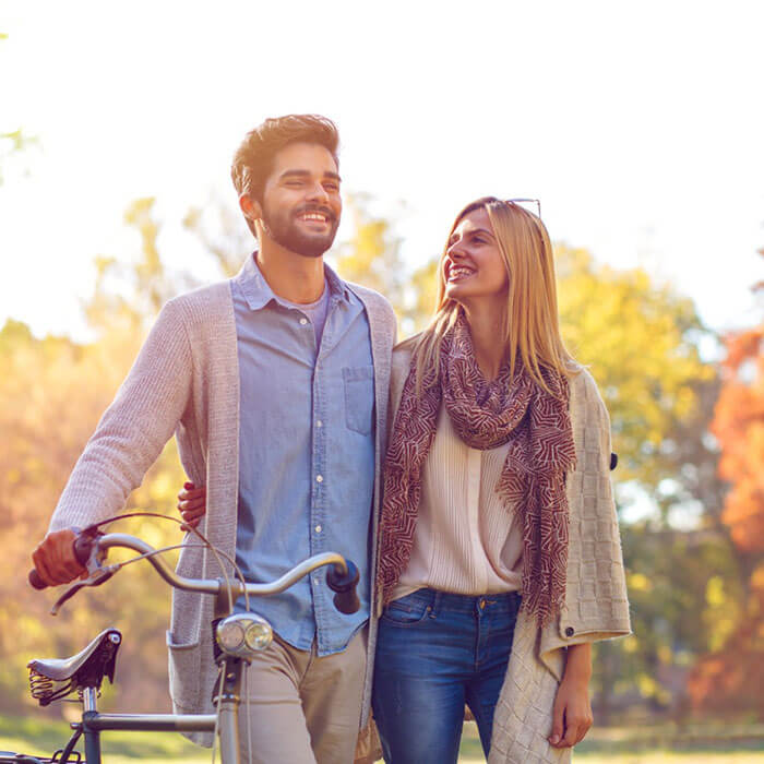 couple smiling outdoors with bike