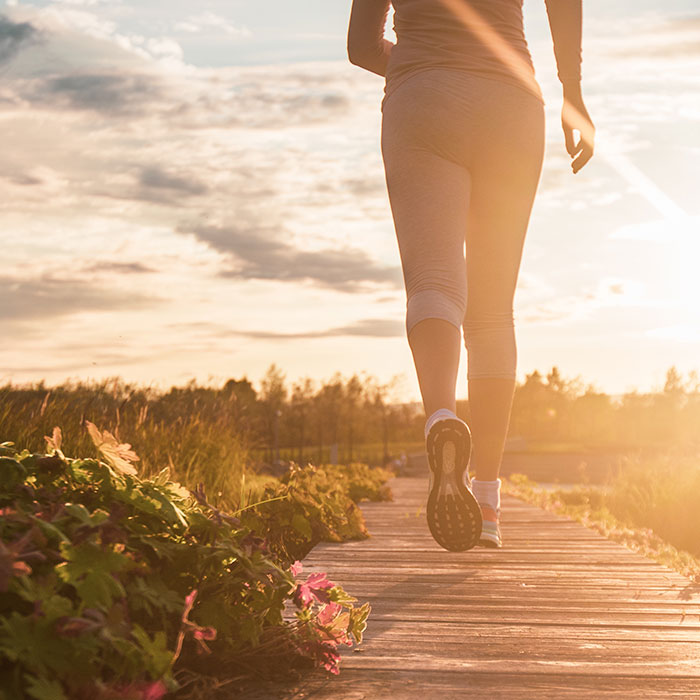 low view of trail greenery with woman walking away