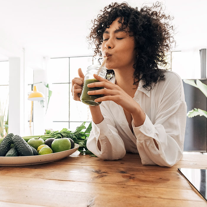 woman happily drinking healthy juice