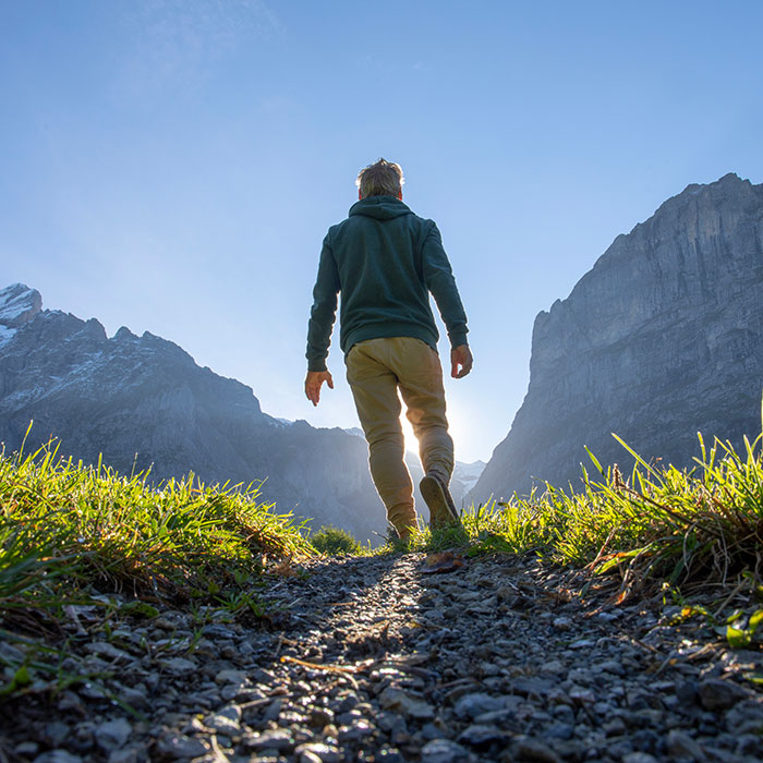 man in valley looking towards mountains