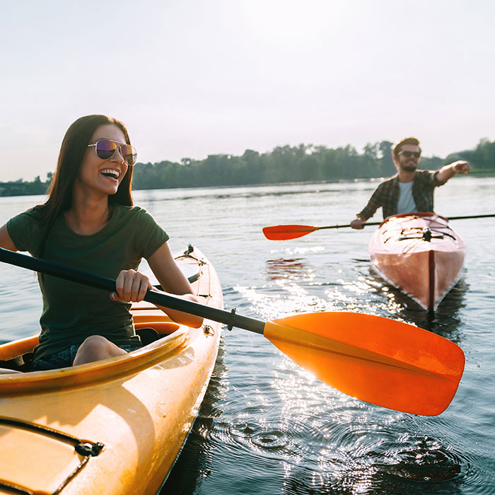 man and woman kayaking in water
