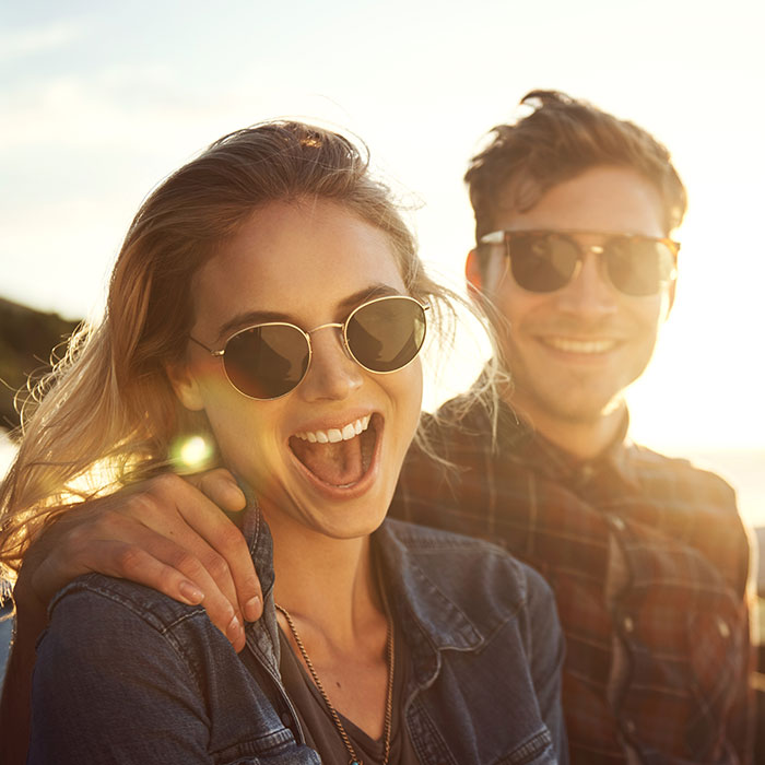 man and woman wearing sunglasses and smiling